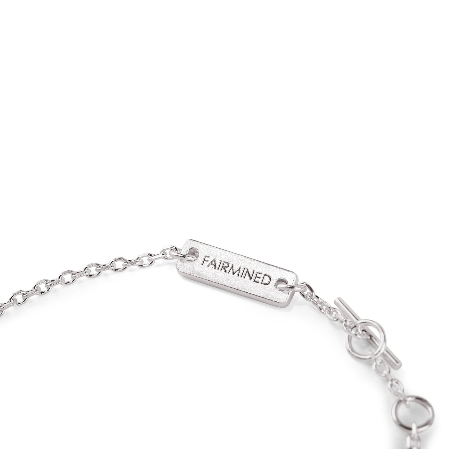 Nahaufnahme des verstellbaren Verschlusses eines Armbands aus Fairmined Silber mit Gravur „Fairmined“, freigestellt auf weißem Hintergrund