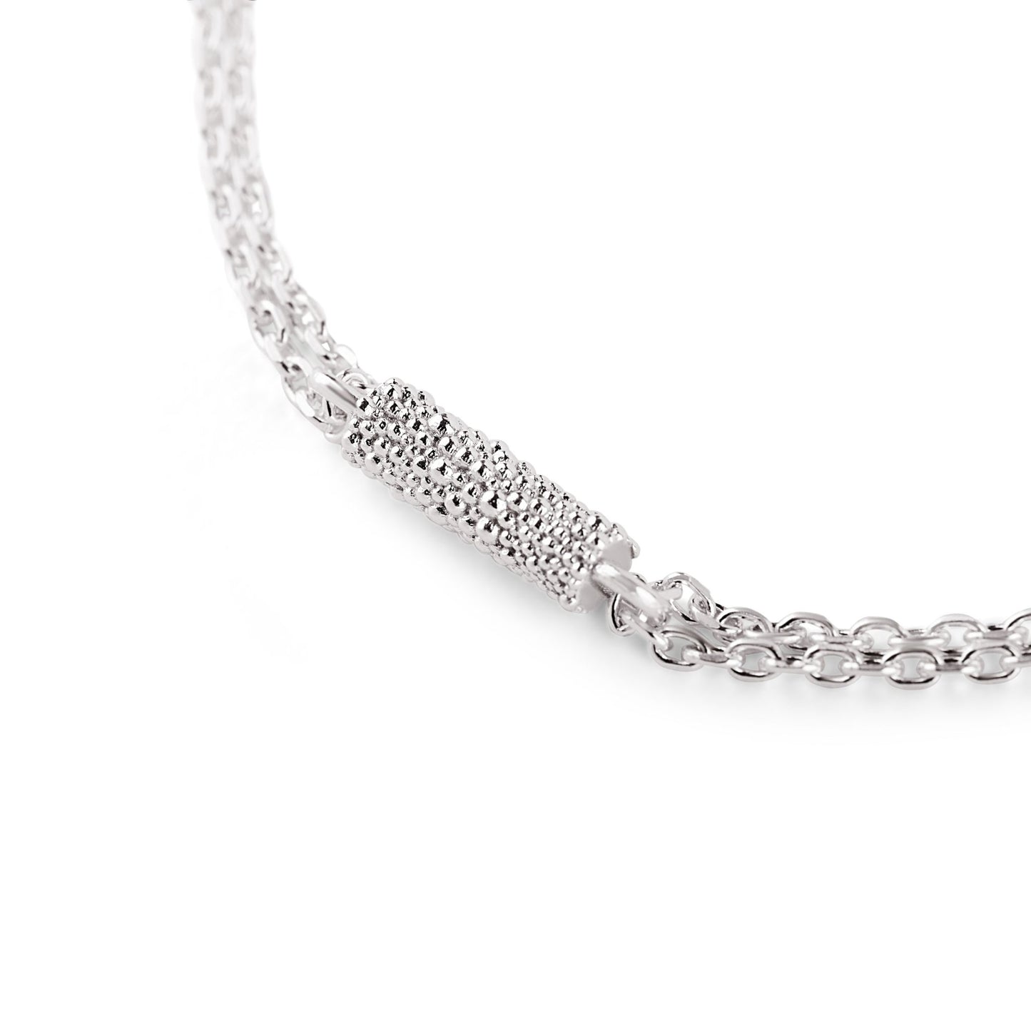 Nahaufnahme eines länglichen Charms aus Fairmined Silber, besetzt mit vielen kleinen Kügelchen, freigestellt auf weißem Hintergrund