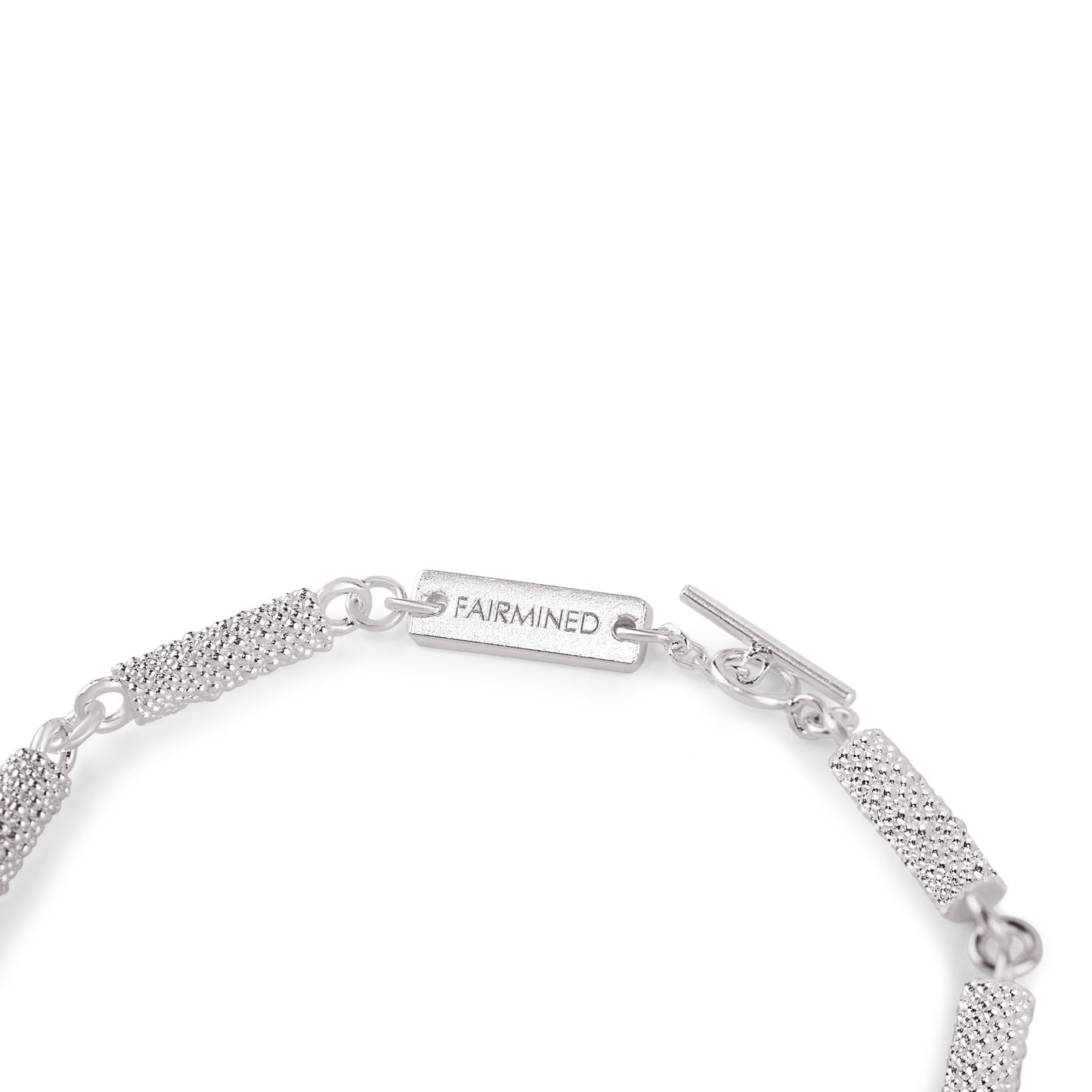 Nahaufnahme des Verschlusses eines Armbands aus Fairmined Silber mit Gravur „Fairmined“, freigestellt auf weißem Hintergrund