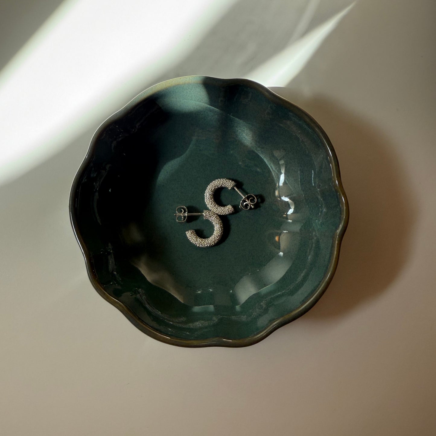 Creolen aus Fairmined Silber, liegend in kleinem Keramikschälchen bei atmosphärischem, natürlichem Licht
