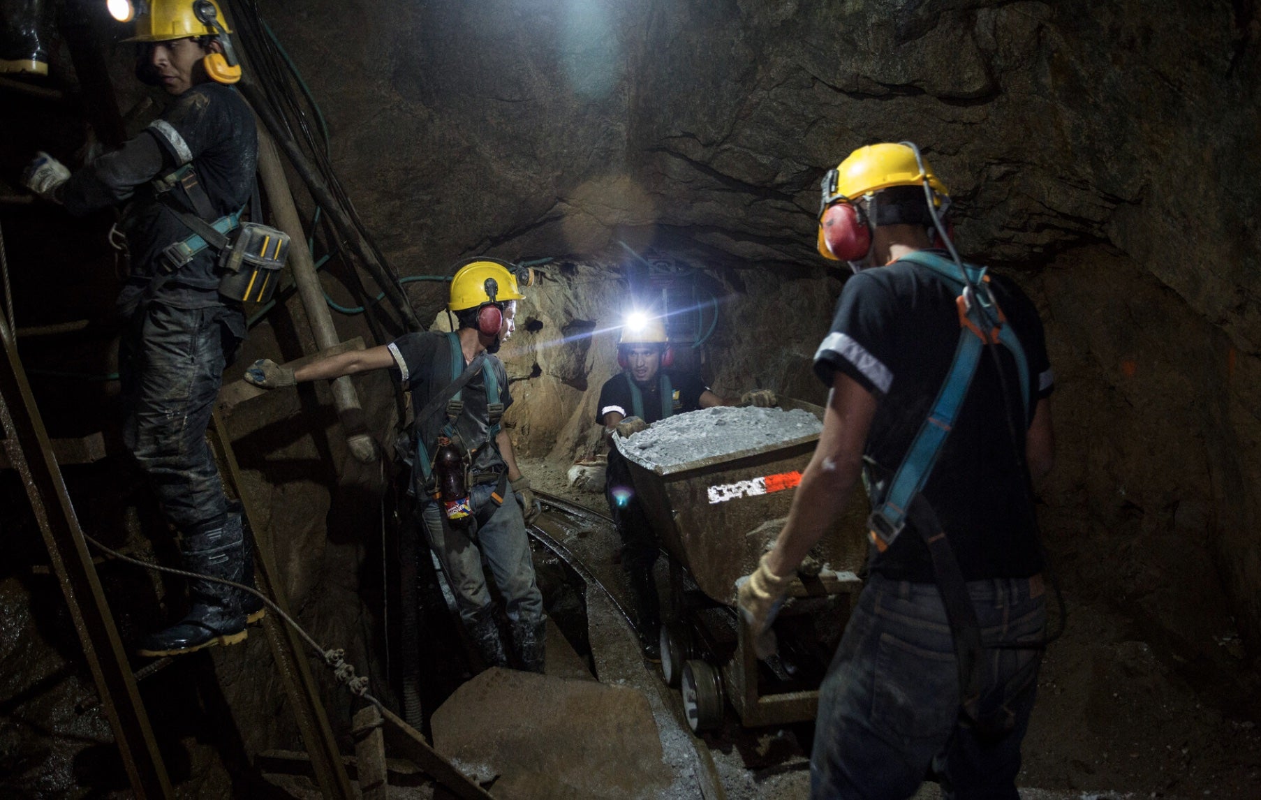 Innenaufnahme von vier Arbeitern mit Schutzkleidung und Helmen in der Fairmined-zertifizierten Mine Chede in Kolumbien