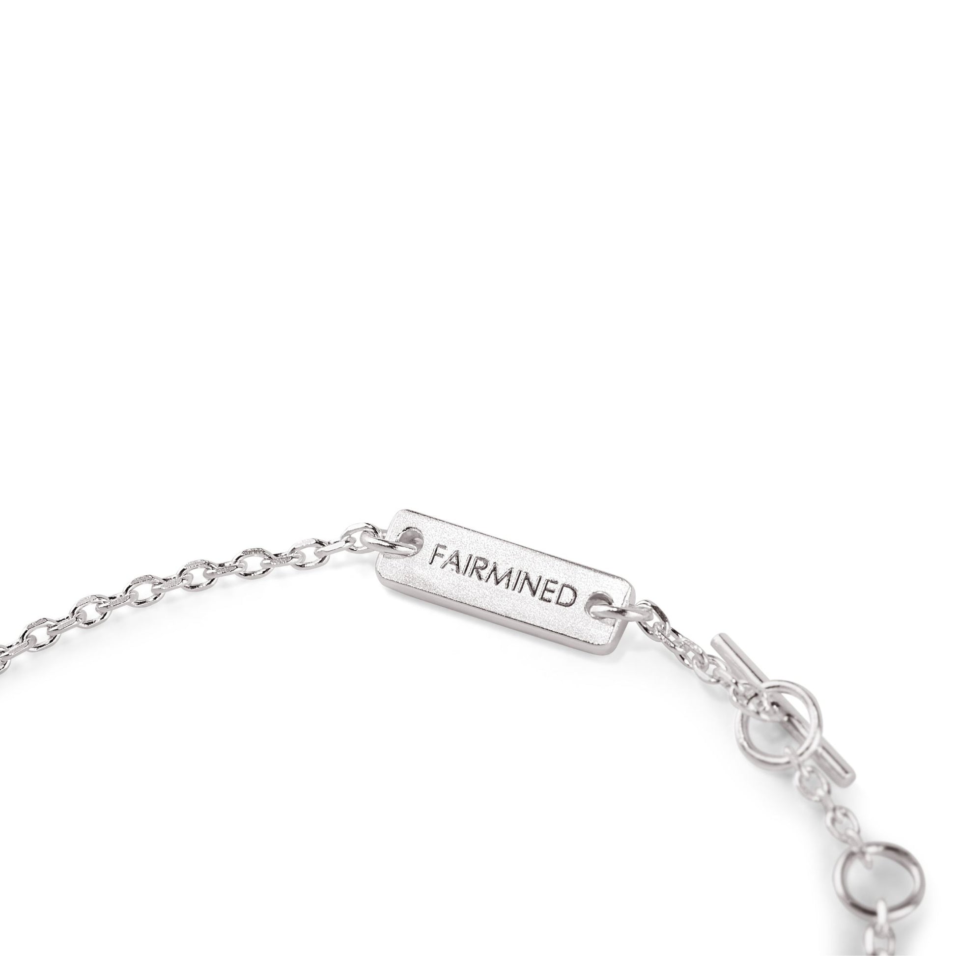 Nahaufnahme des verstellbaren Verschlusses eines Armbands aus Fairmined Silber mit Gravur „Fairmined“, freigestellt auf weißem Hintergrund