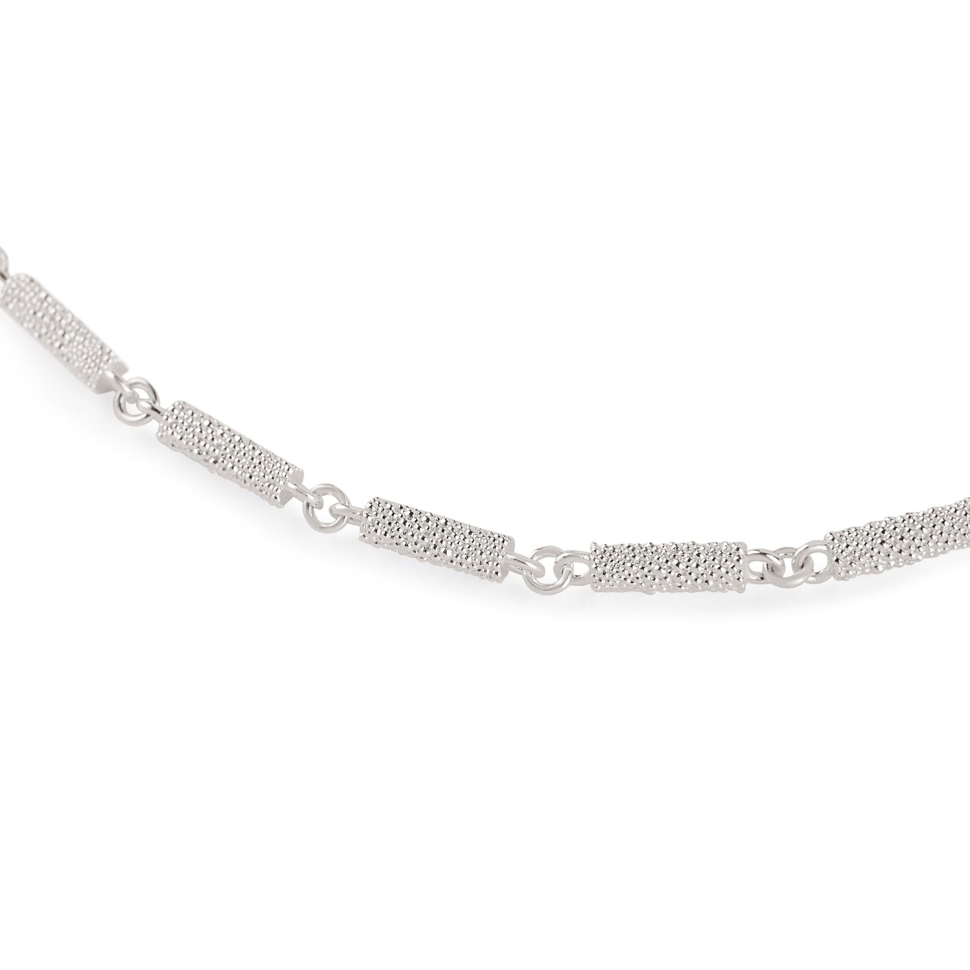 Nahaufnahme der Kettenglieder einer Fairmined Silber Halskette, längliche Elemente mit zahlreichen kleinen Kügelchen besetzt, freigestellt auf weißem Hintergrund
